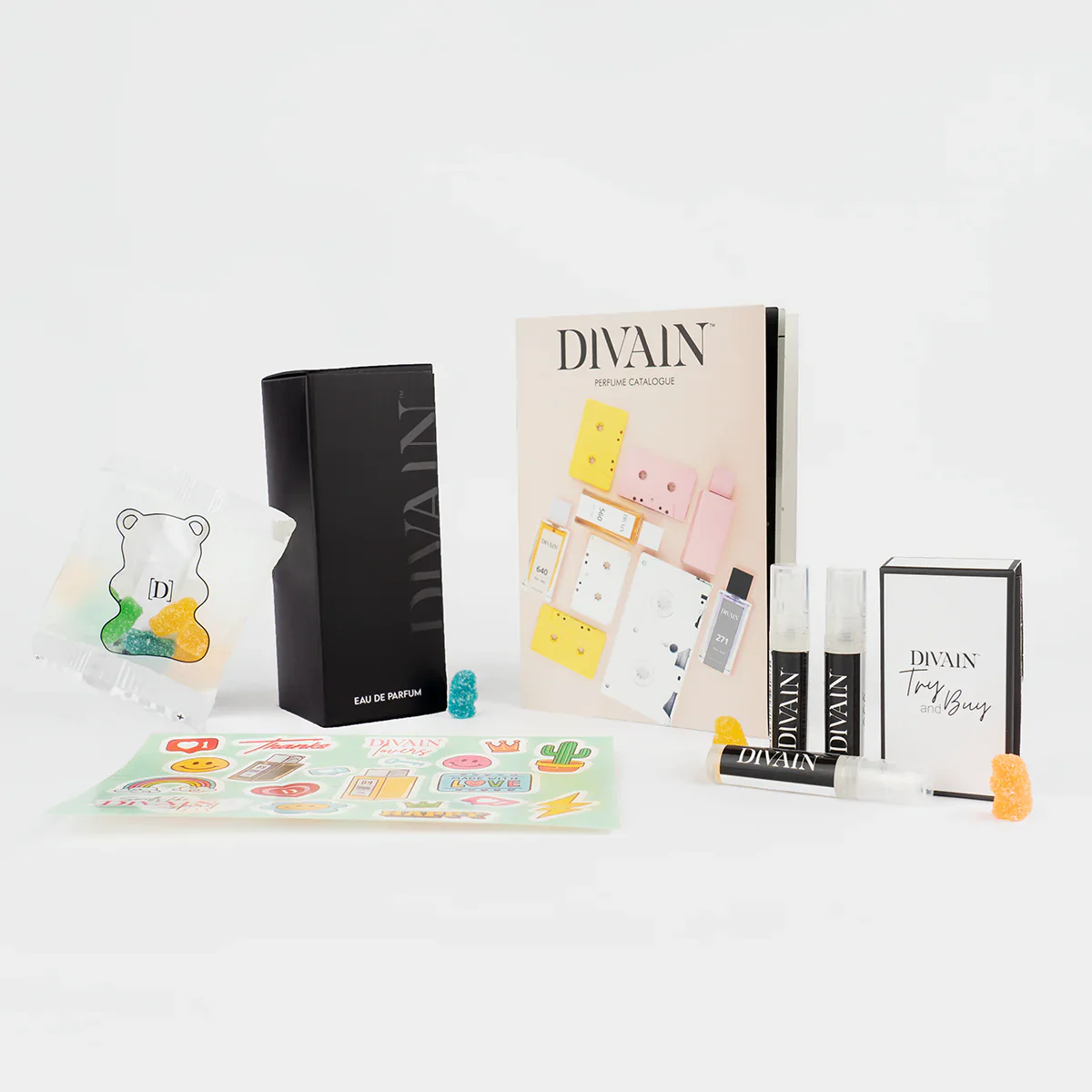 Opened divain package containing divain-367 perfume, stickers, and gummy candies
